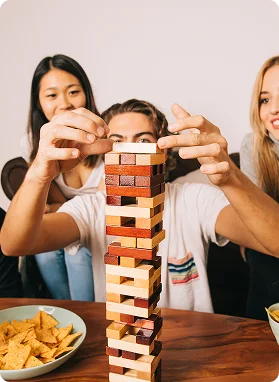 Ludzie grają w grę planszową Jenga.